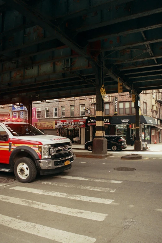 an ambulance is on the street under a bridge