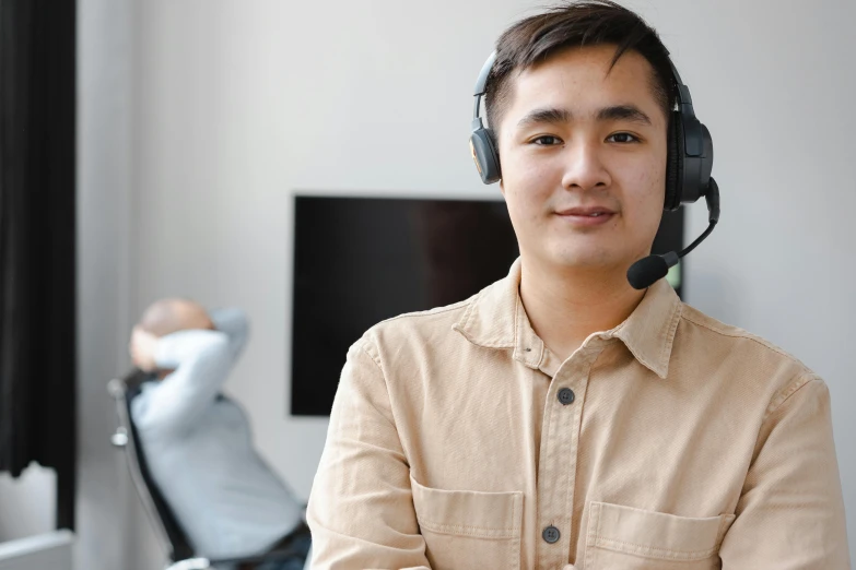 a man wearing headsets sitting in an office