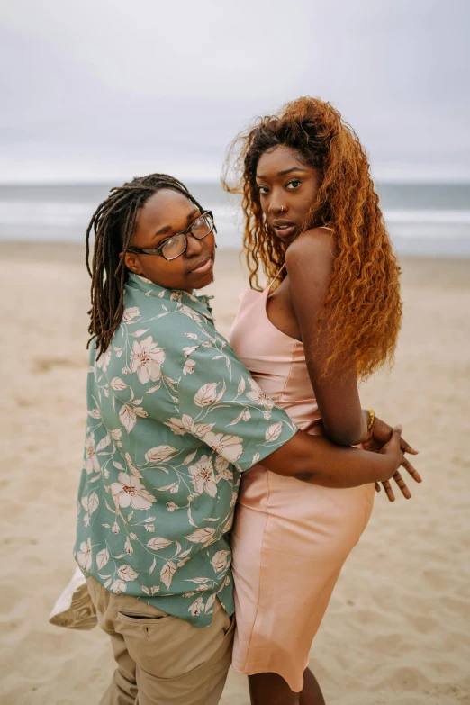 two woman hugging on a beach on a cloudy day