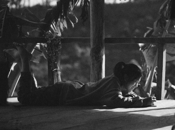 a woman laying on the ground reading a book