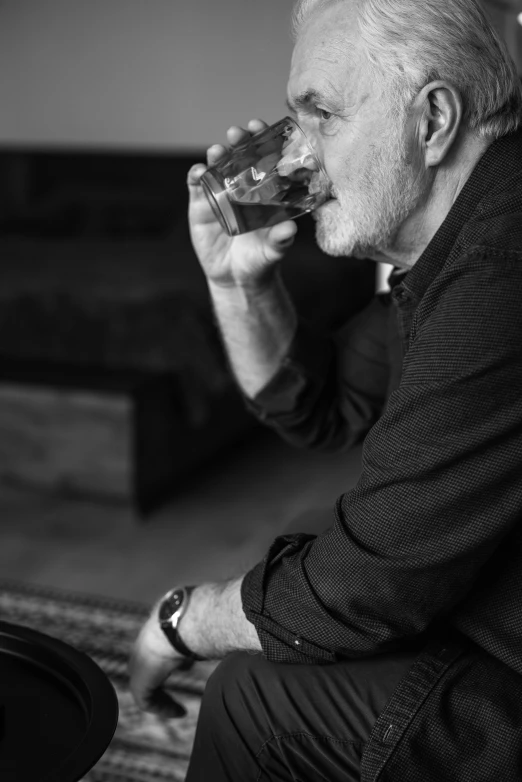 a man sits and sips from a glass