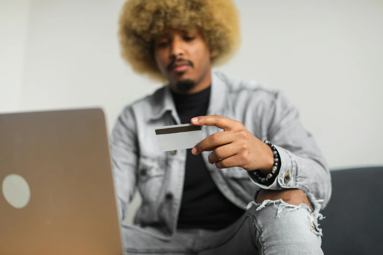 a man with afro hair holding a small business card