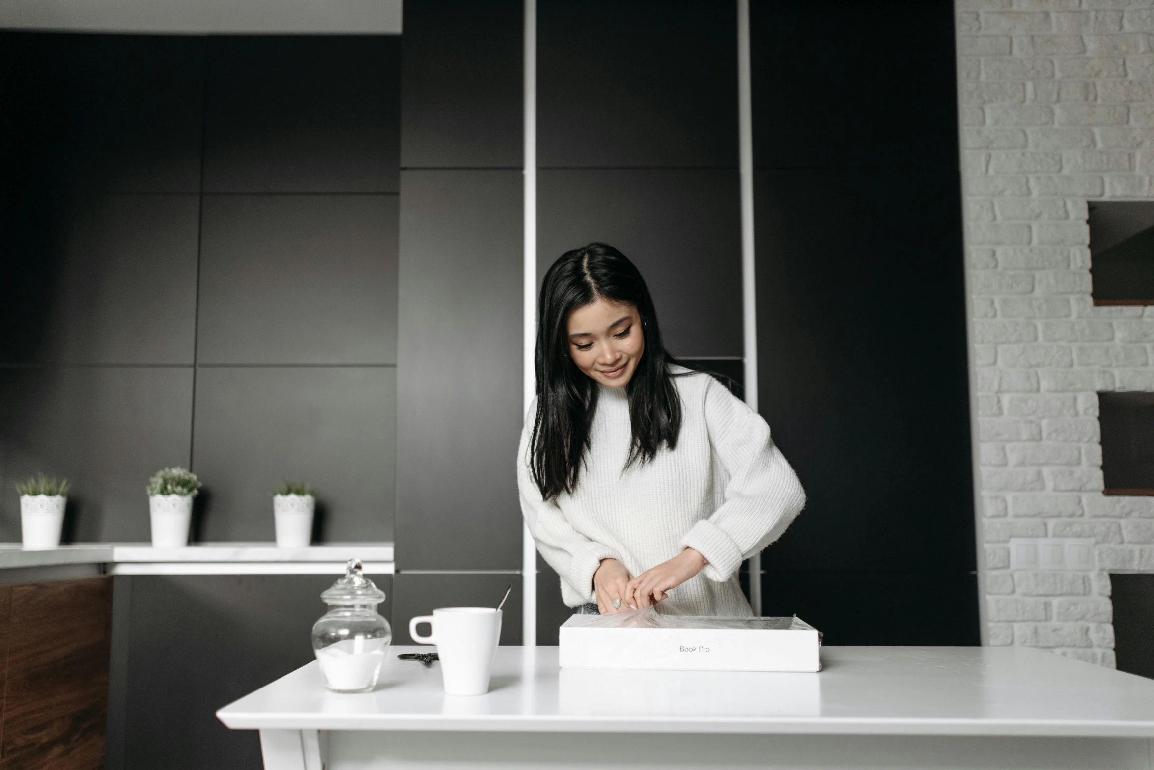 a woman standing in front of a table with a white box