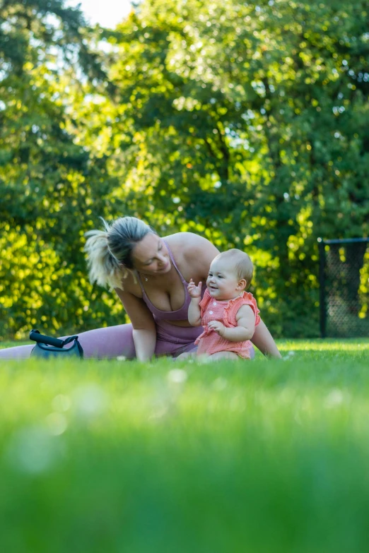 the lady is holding a baby and kissing her chest