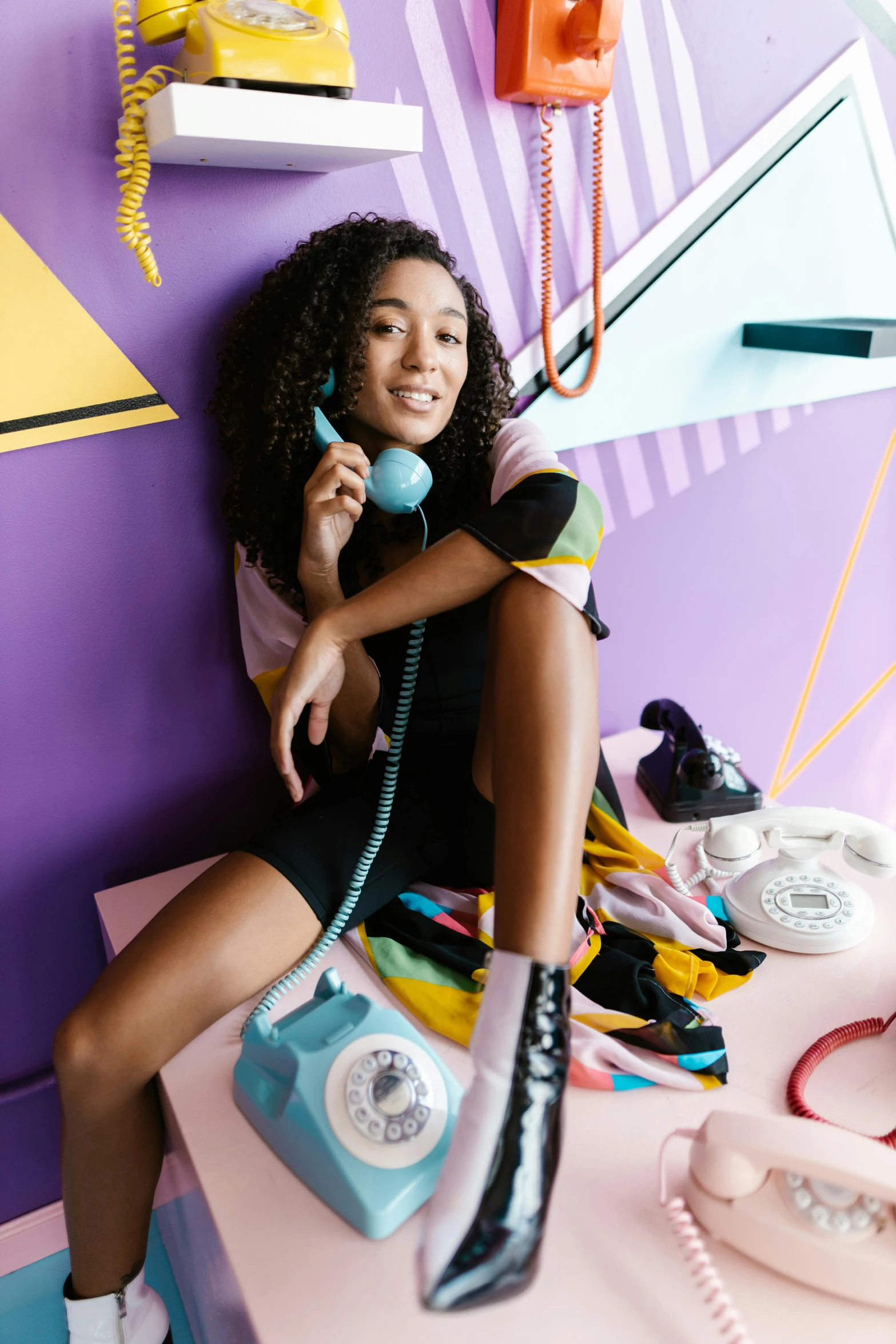 a woman sitting on a table holding a telephone and looking up