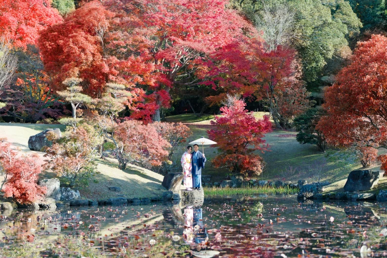 a man standing in a pond while holding an umbrella