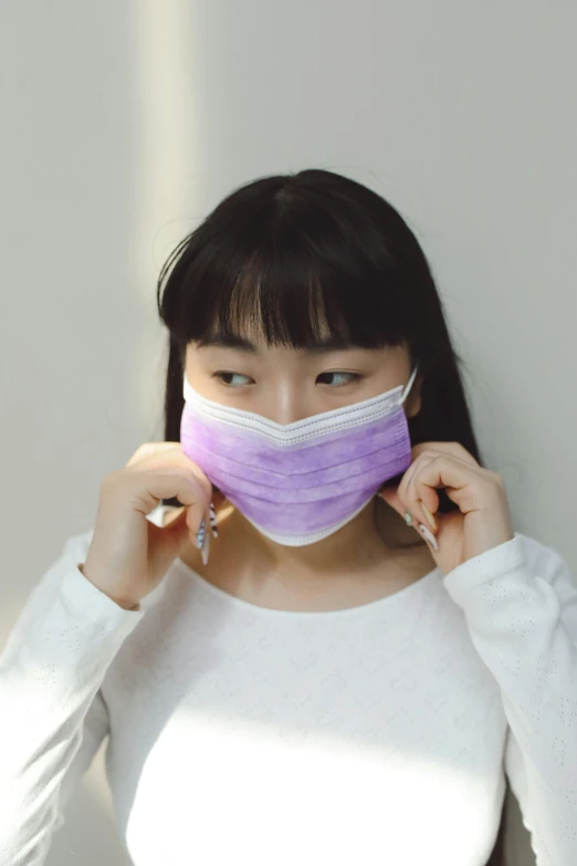 a woman wearing a face mask with light reflecting on her face
