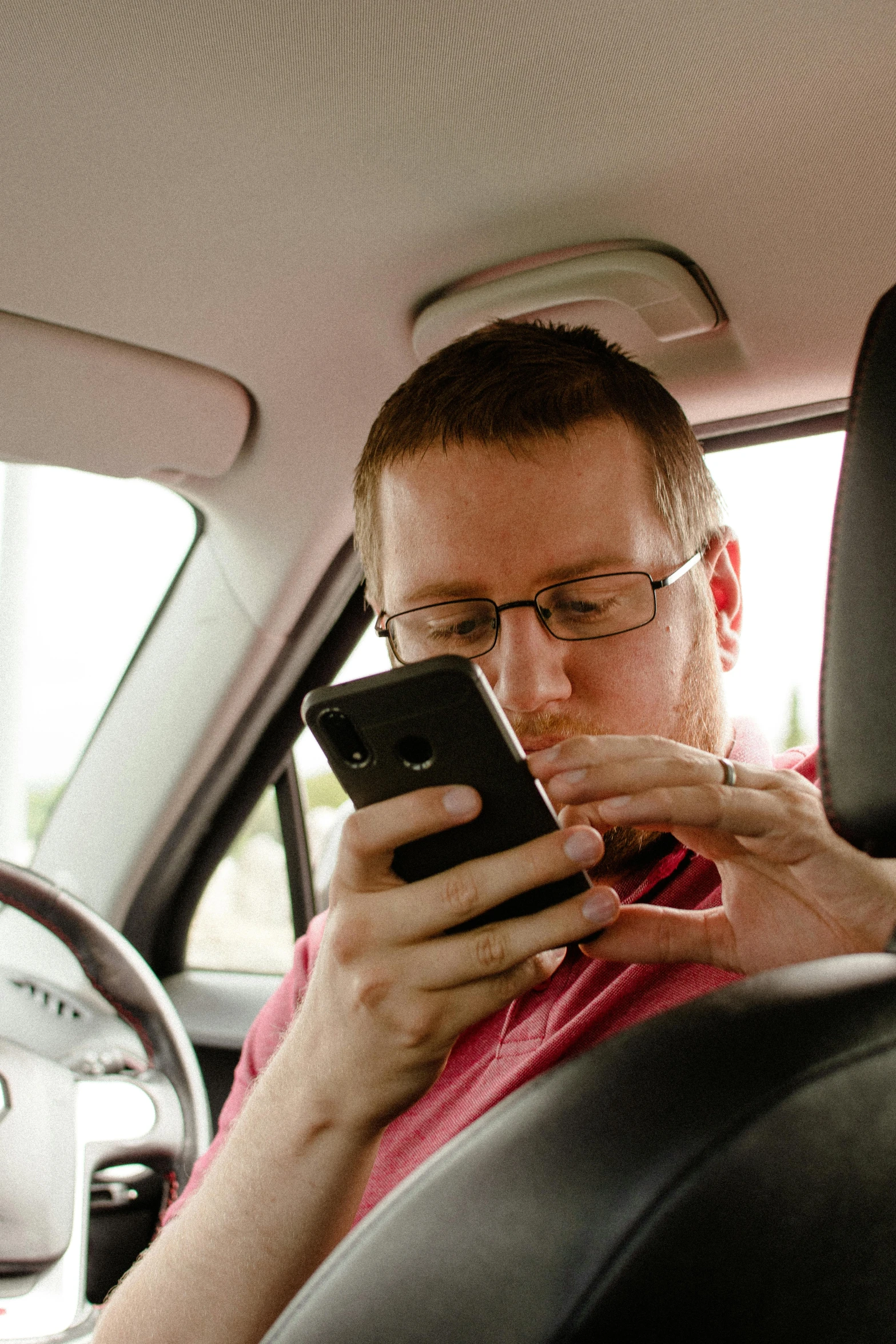 a man using a phone while in the back seat of a car