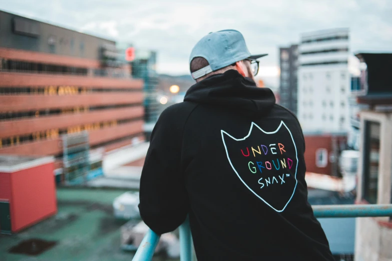 man wearing batman hoodie overlooking the cityscape