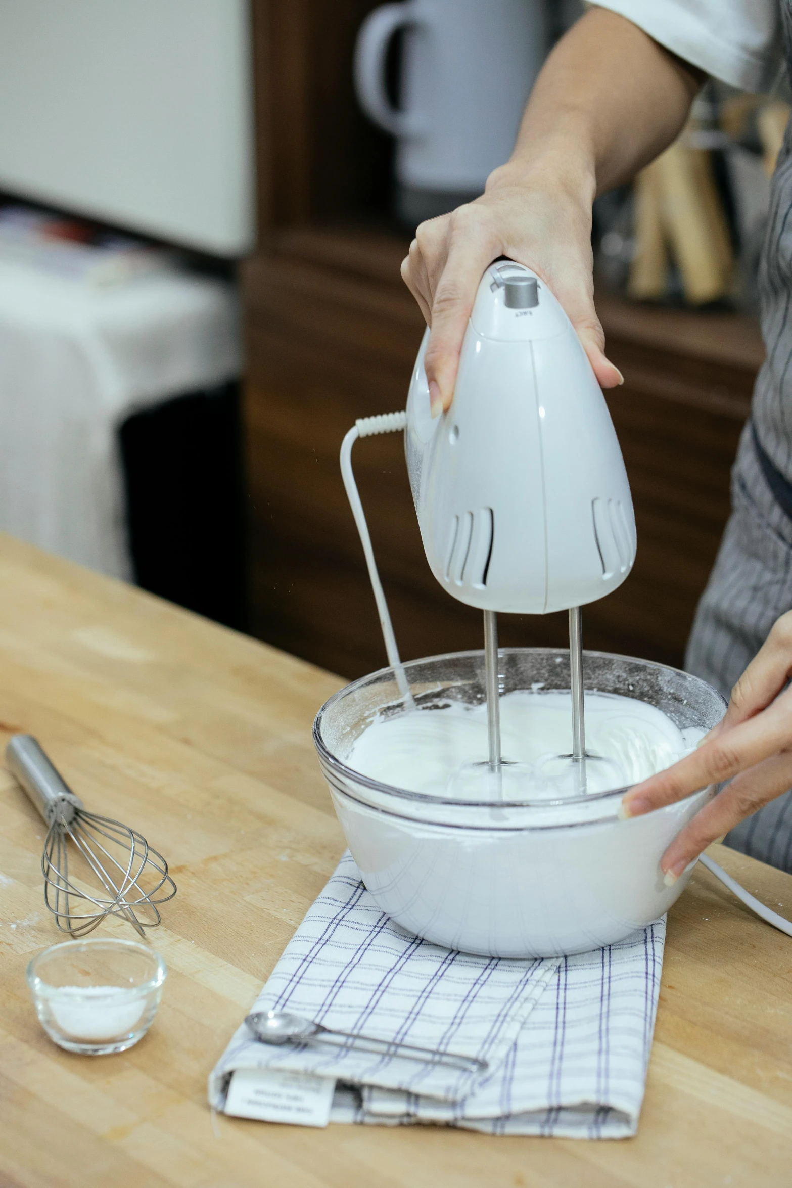 someone using a hand mixer to beat out a batter