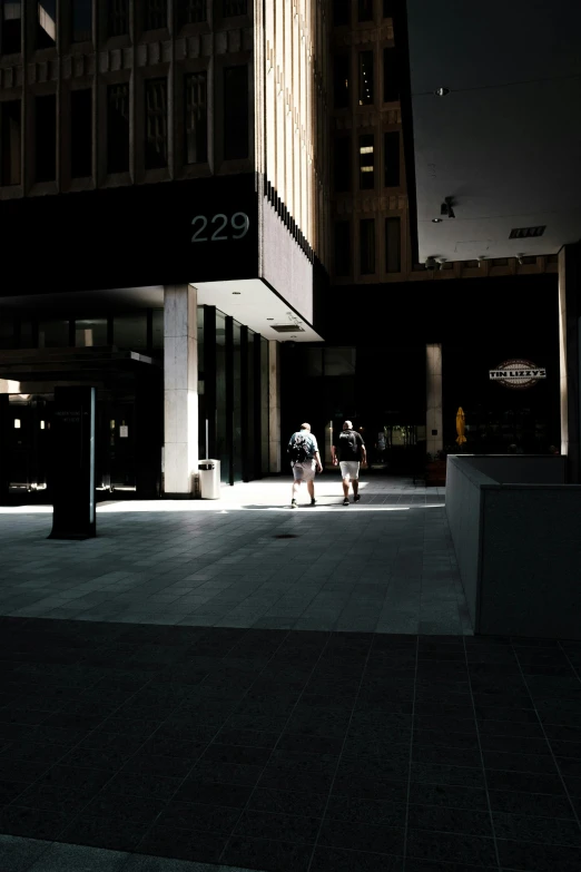 three people are sitting down outside an office building