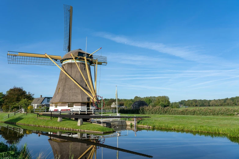 windmill being built near the water of a farm