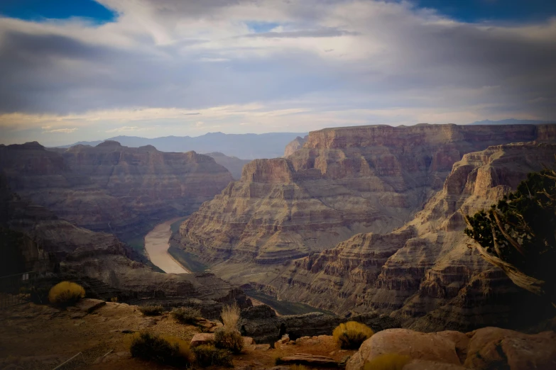 a cliff in the middle of a desert with a body of water behind it