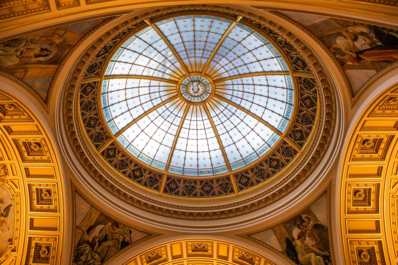 an ornate building with a glass ceiling and gold detailing