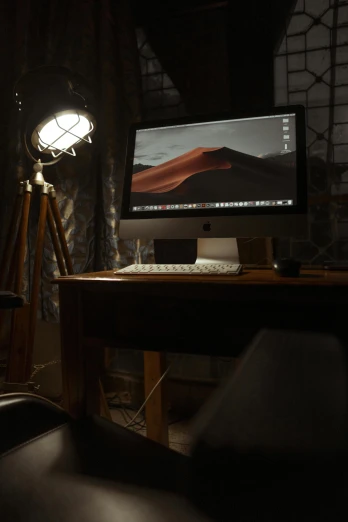 a desktop computer set up on a desk with a desk lamp and chair