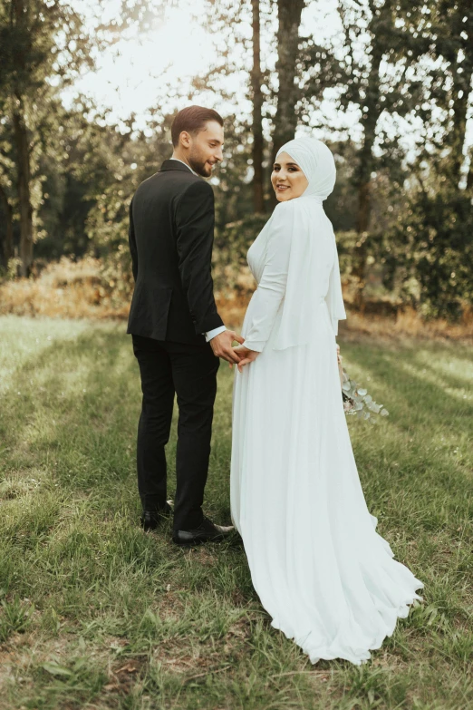 a man and woman hold hands in a field