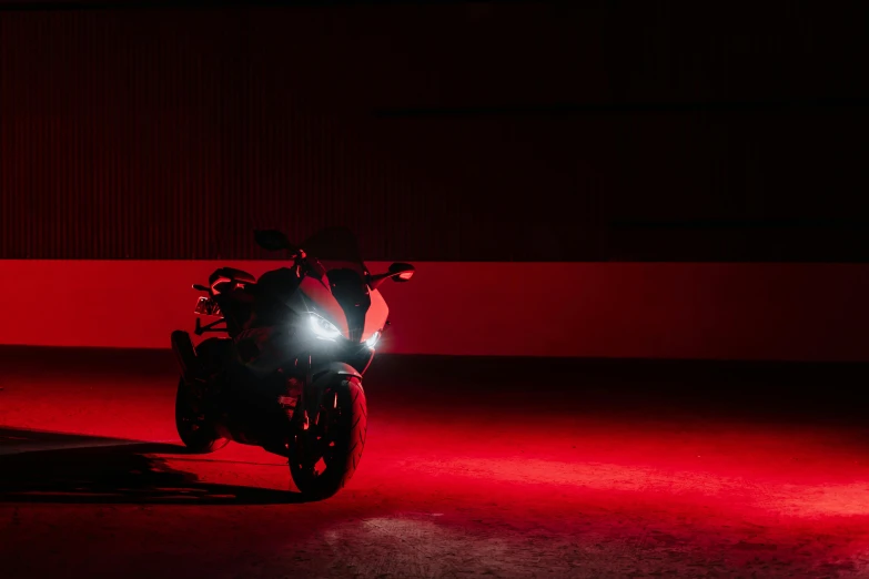 a motorcycle driving at night in a red lighting