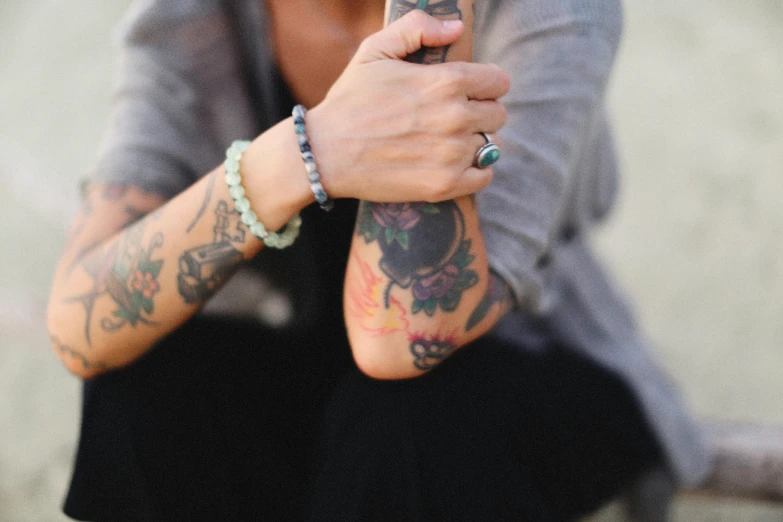a tattooed man holding onto a cell phone in his hands