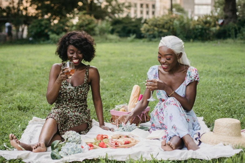 two beautiful young women sitting in the grass