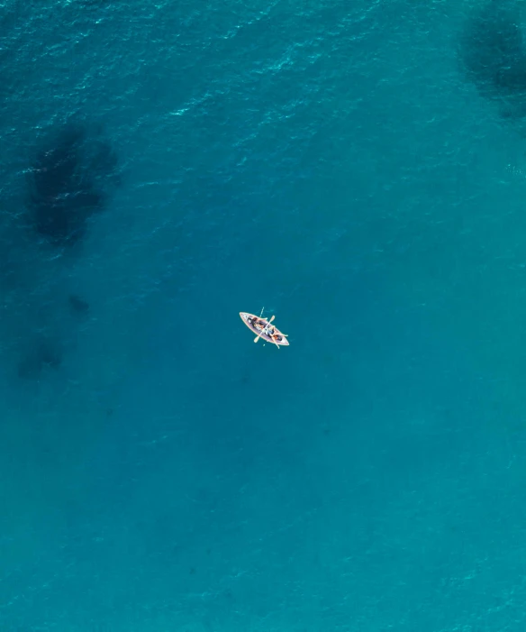 a small boat is floating in the blue water