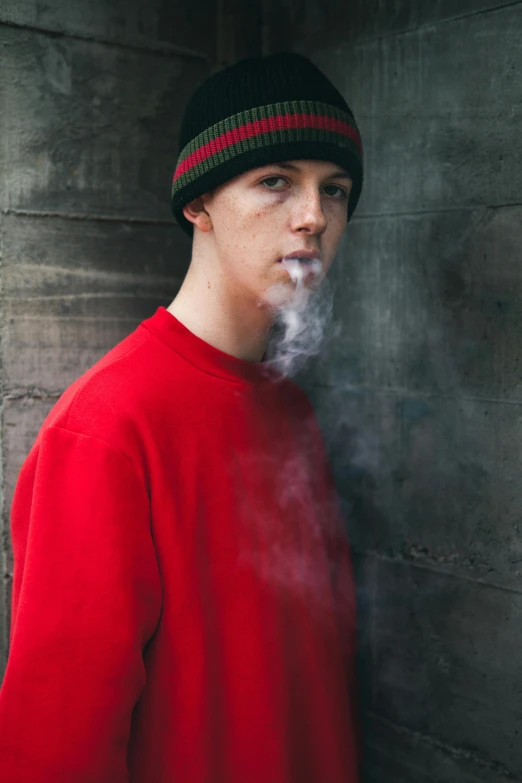 a man in red sweater smoking a cigarette