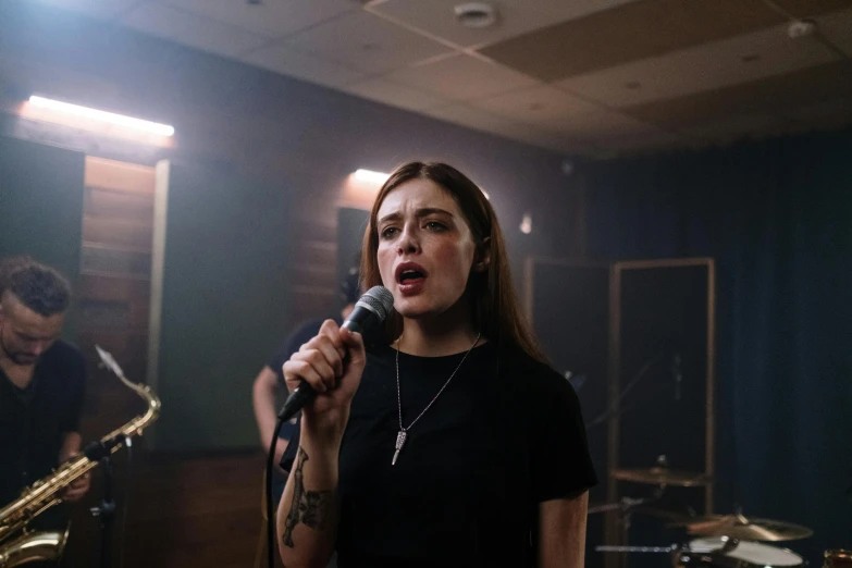 woman standing next to a microphone and singing