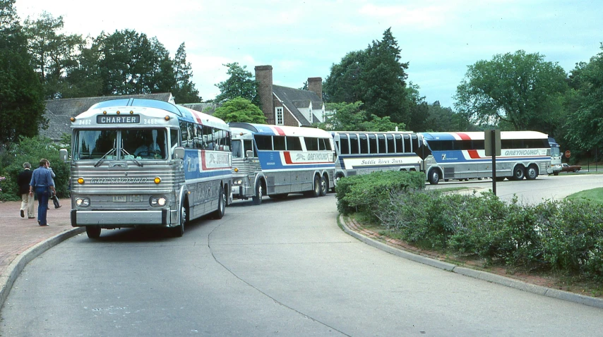 many buses parked along the curb to pick up passengers