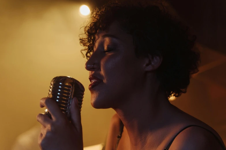 a woman singing into a microphone in a dark room
