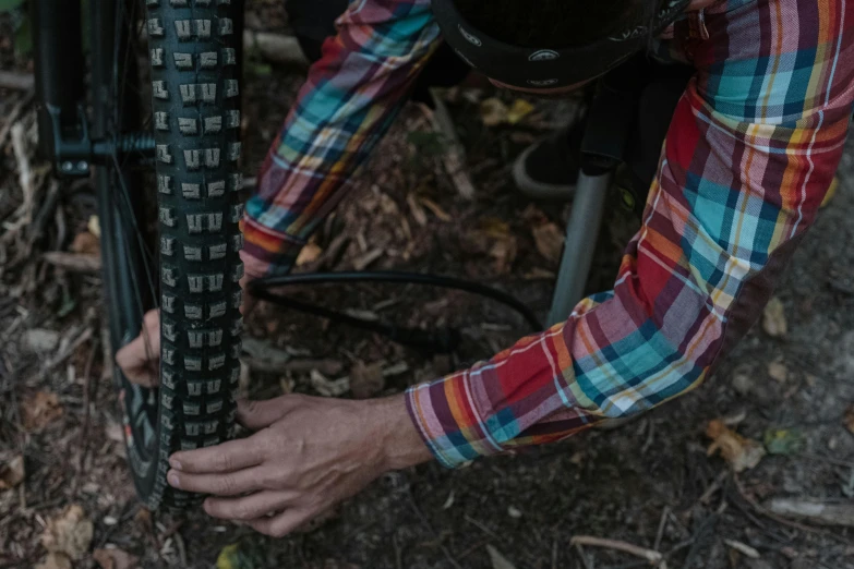 a person holds their bike in front of the tire