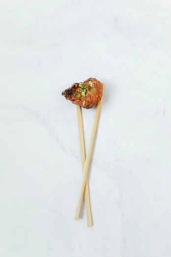 two small skewers that have meat on them