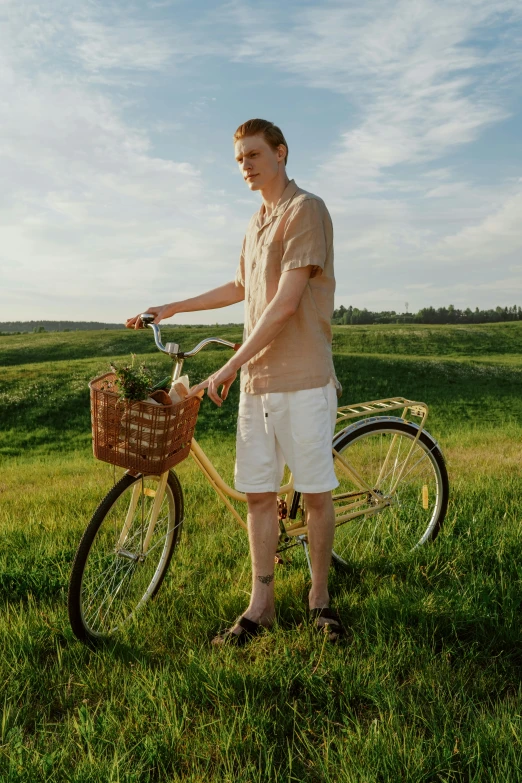 a man standing next to his bike in the grass