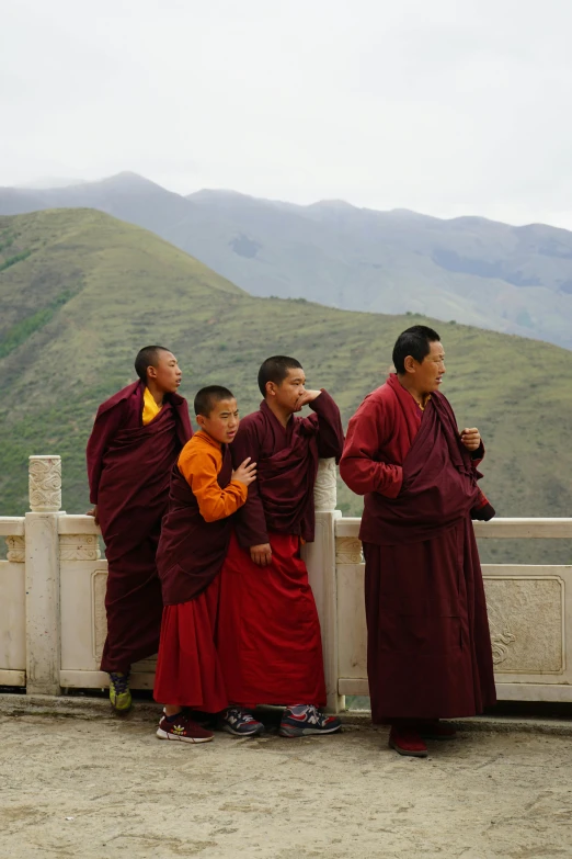 the monks are standing near a small fence