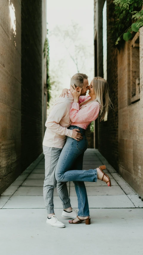 a man and woman emcing and walking together down an alley way