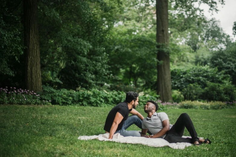 two young men enjoying a picnic in a park