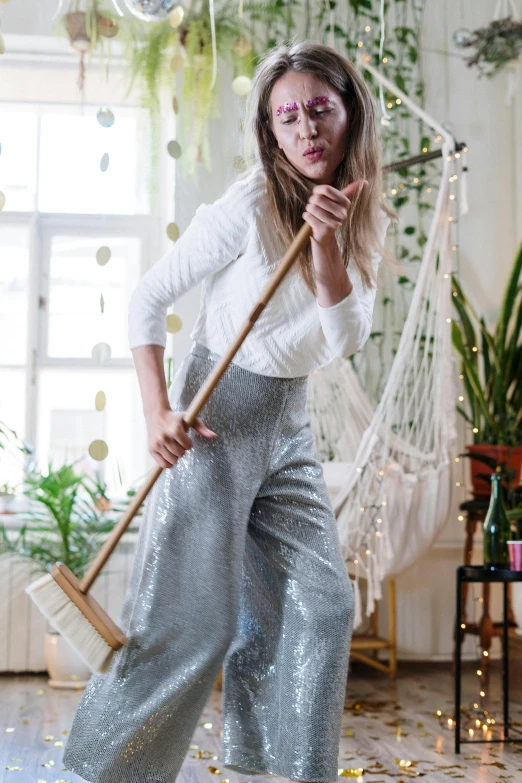 the woman is posing with her broom outside