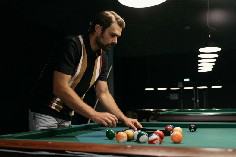 a man playing pool with his cues