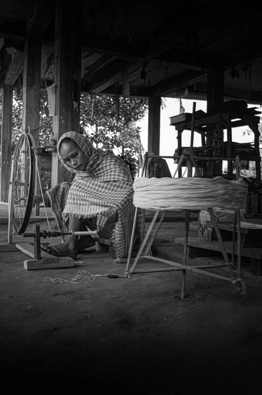 an indian woman works with woven on a loom