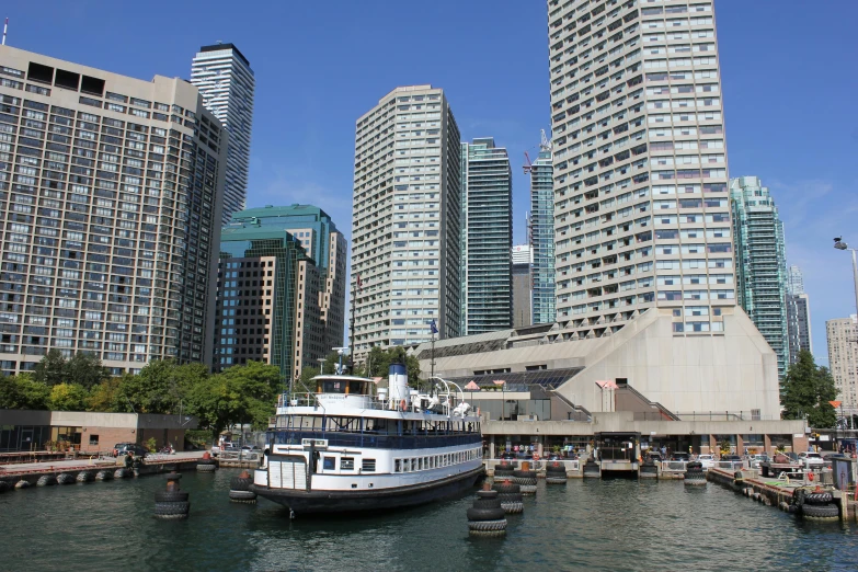 a large white and black boat on water near tall buildings