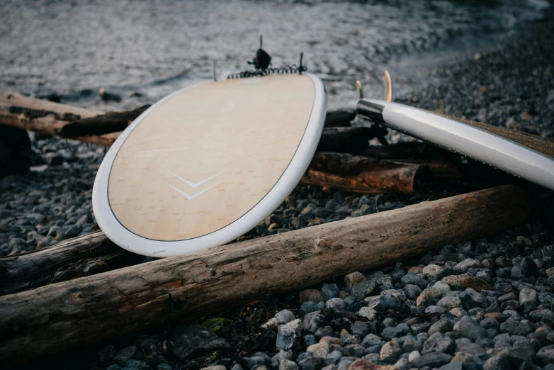 a wooden paddle and brush sitting on top of gravel