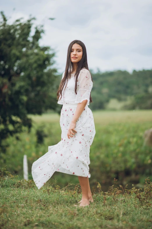 a girl is standing in a field of green grass