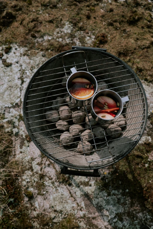 an open barbecue grill with food and water in it