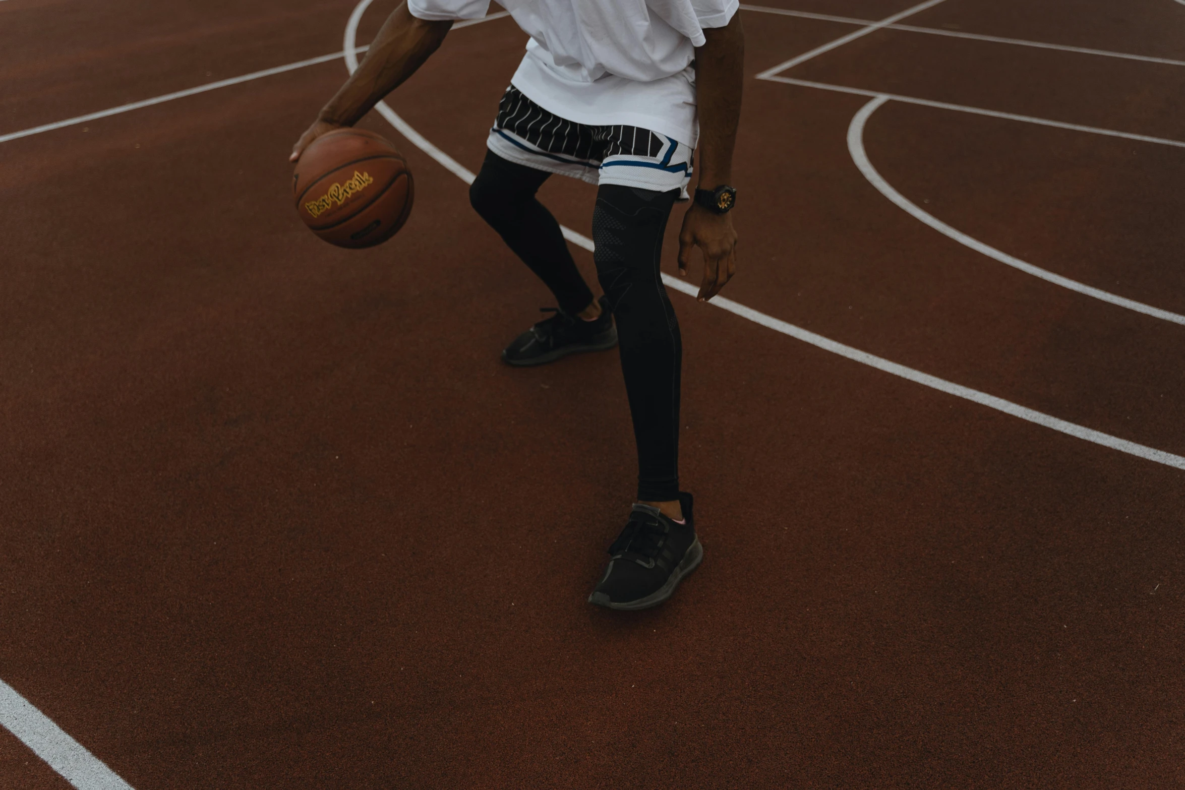 a boy holds a basketball and is wearing his uniform