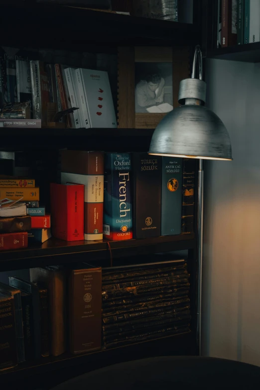 there is a table lamp next to a bookshelf