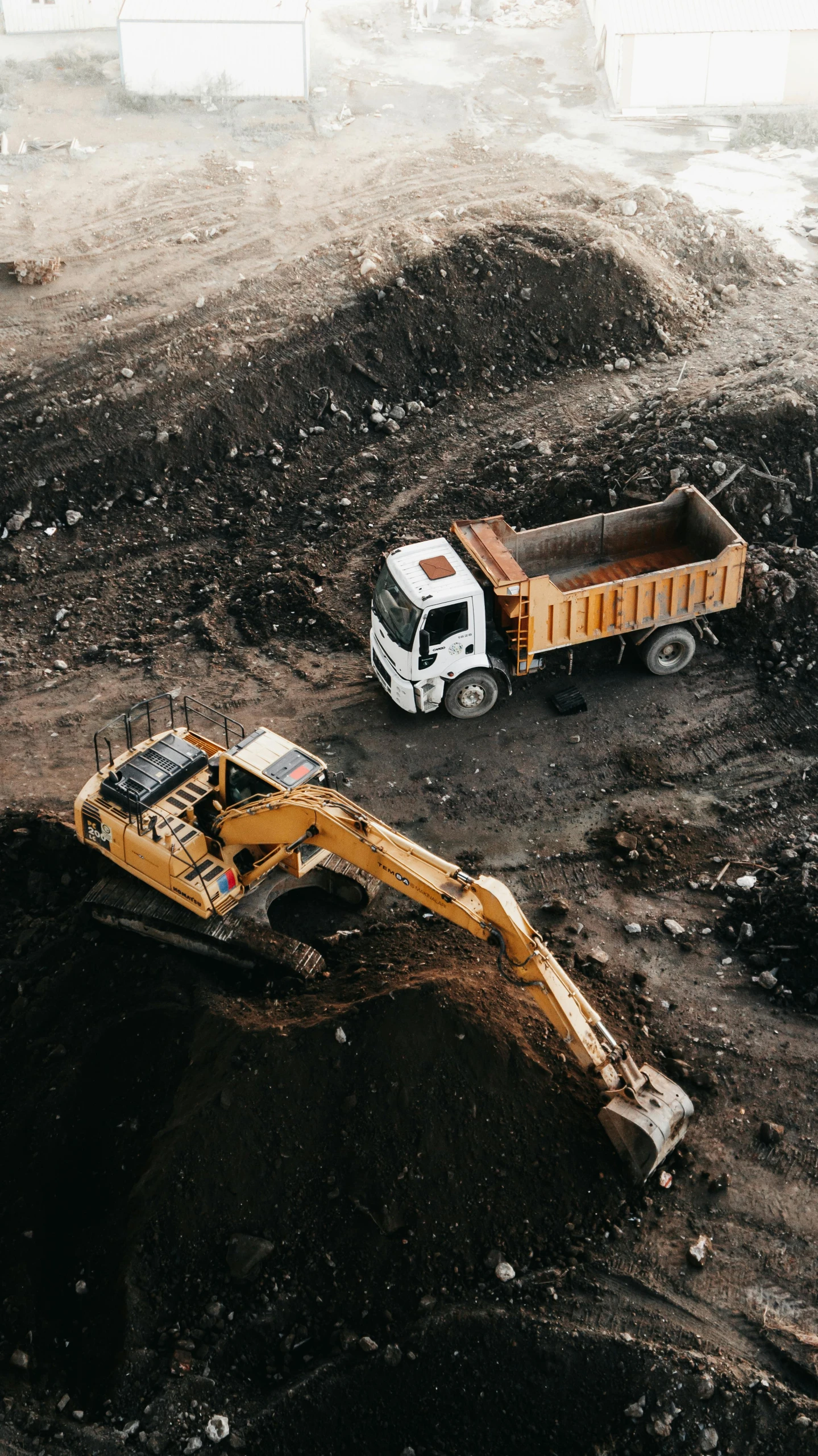 a dump truck near a large construction truck