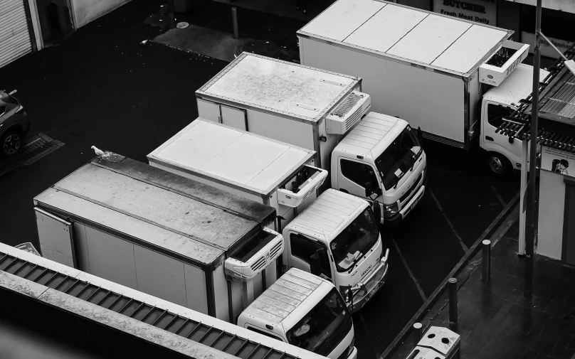 multiple delivery vans are parked in an alley