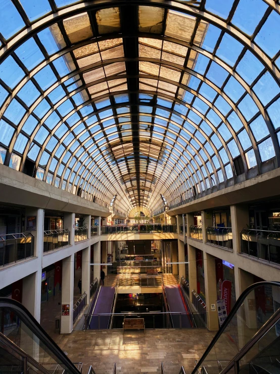 an indoor shopping mall with a few escalators