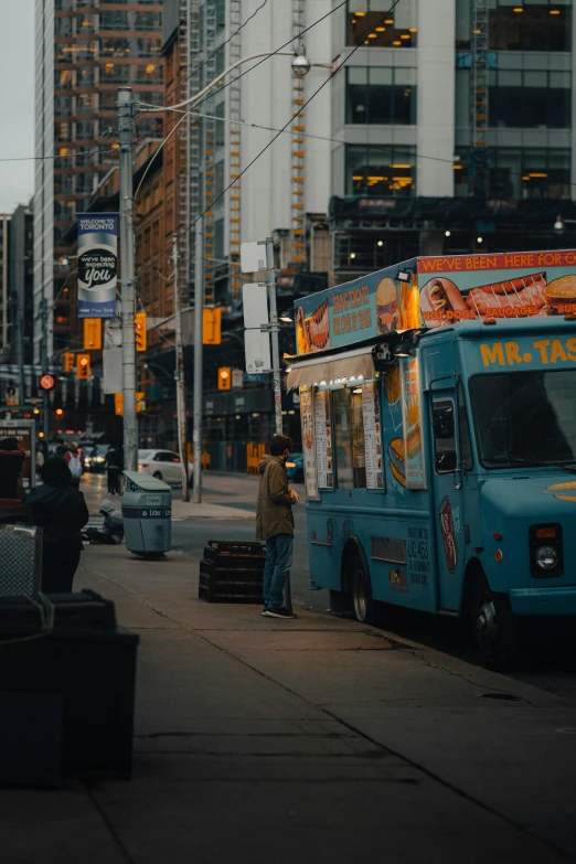 two people standing by an ice cream truck on the street