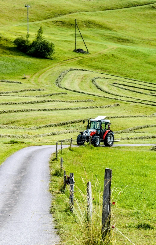 a tractor is driving down a rural road