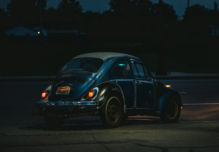 an old beetle on a street during the night