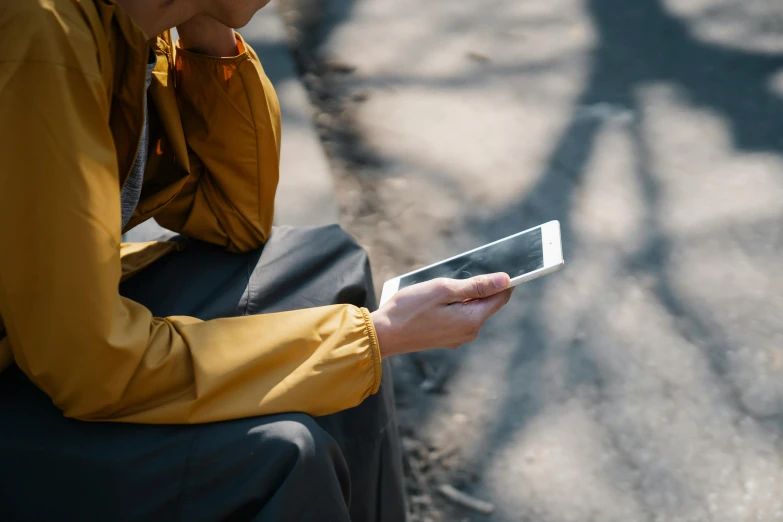 a man in a yellow shirt is holding a tablet